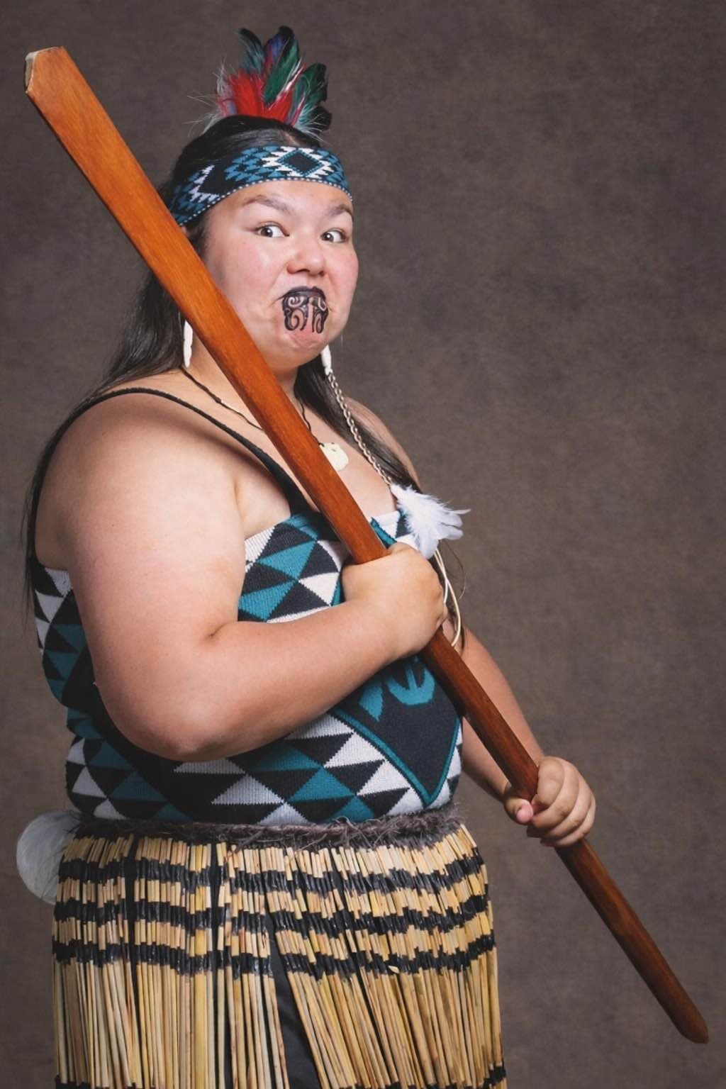 Kapa haka performer in traditional costume with taiaha